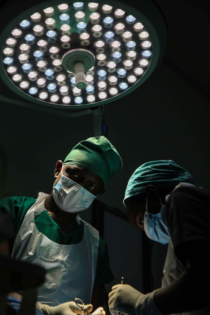gallery-3 Surgical team working under intense lighting in an operating room, focused and masked for safety.