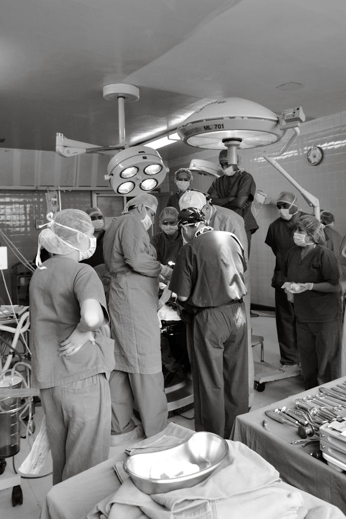 gallery-2 Surgical team performing a medical procedure in a busy operating room. Medical teamwork and precision.