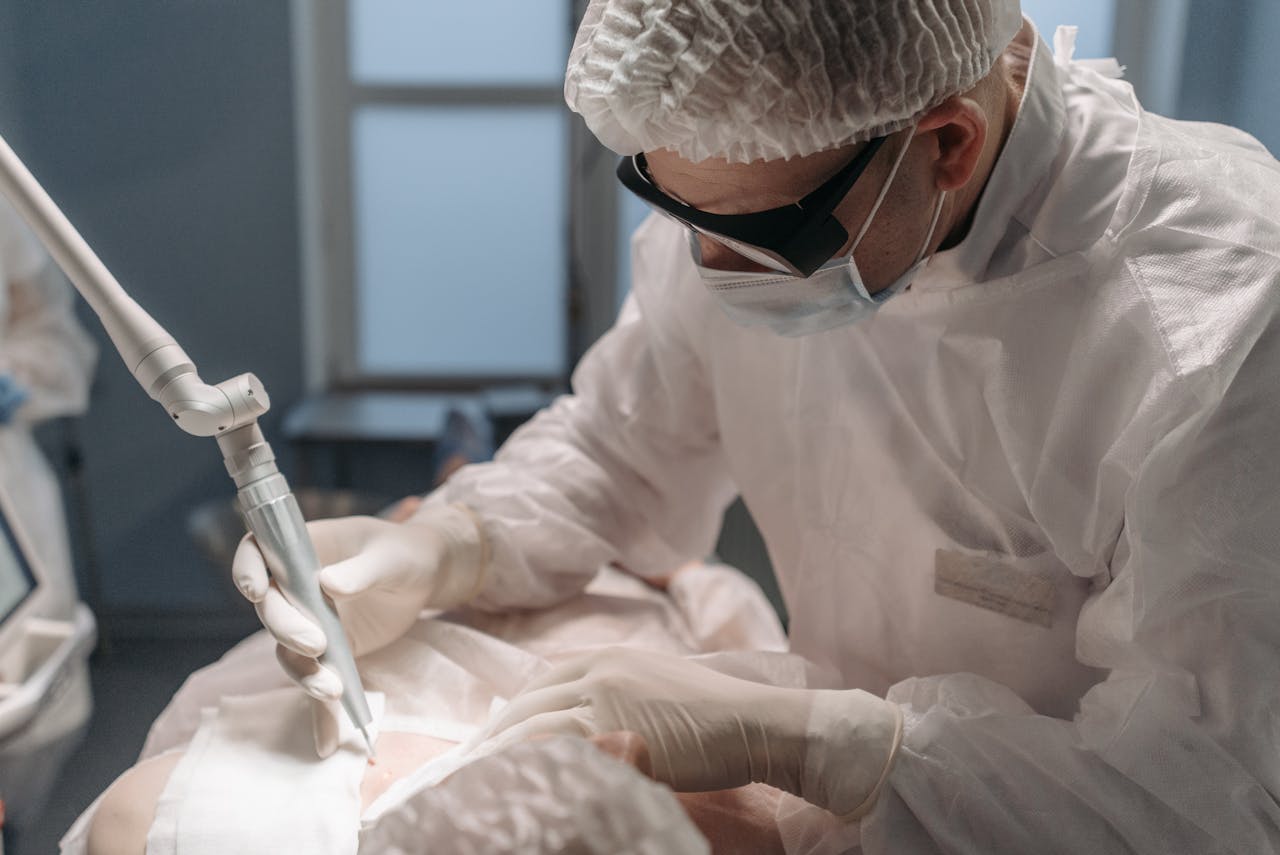 services-02 A focused surgeon performs laser surgery in a sterile operating room, emphasizing precision and care.